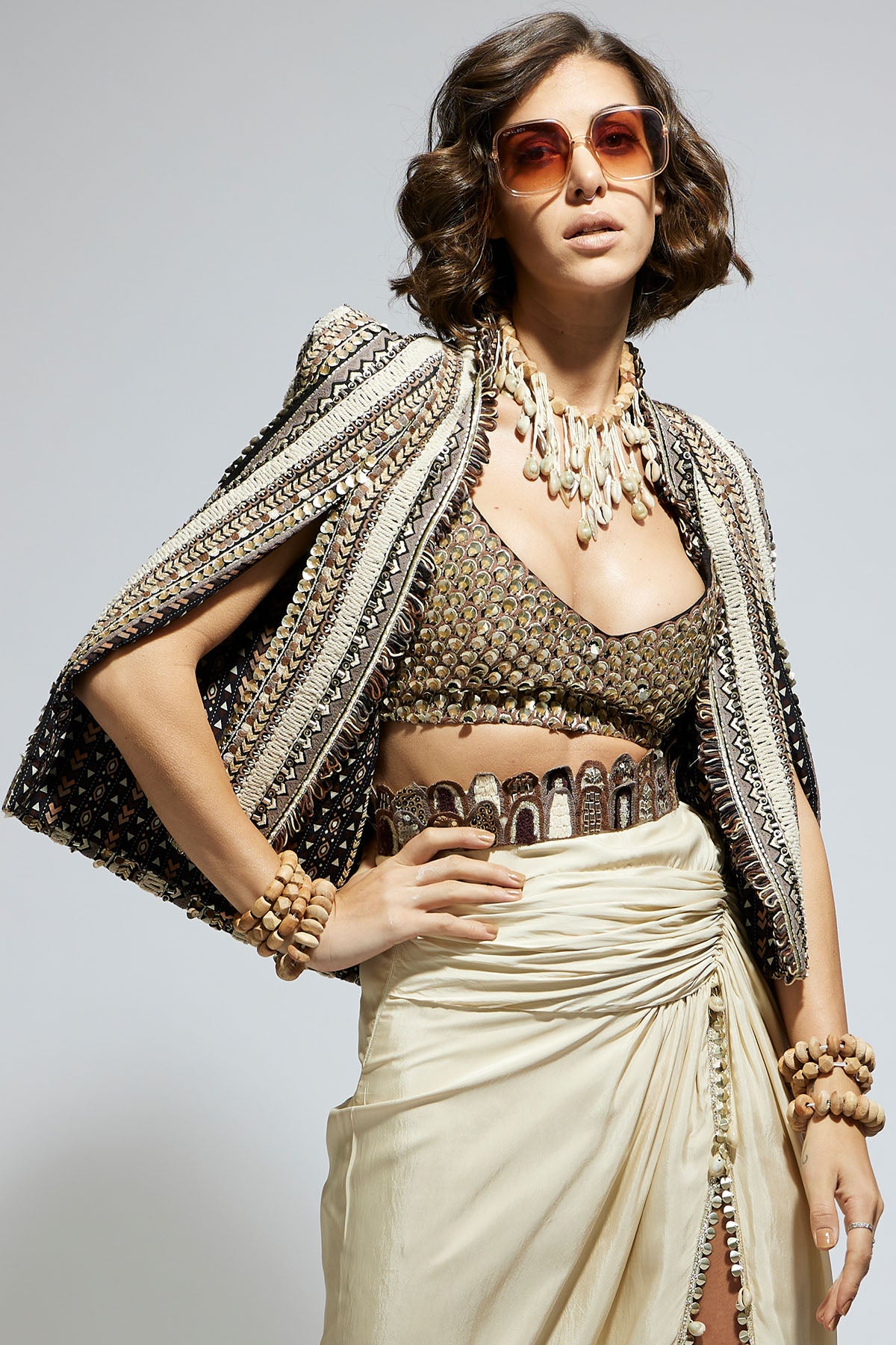 Embellished & Textured Cape Jacket Paired with Metallic Scallop Bustier and Ivory High Slit Skirt