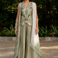 Box pleat pants and an embroidered vest are paired with a long cape