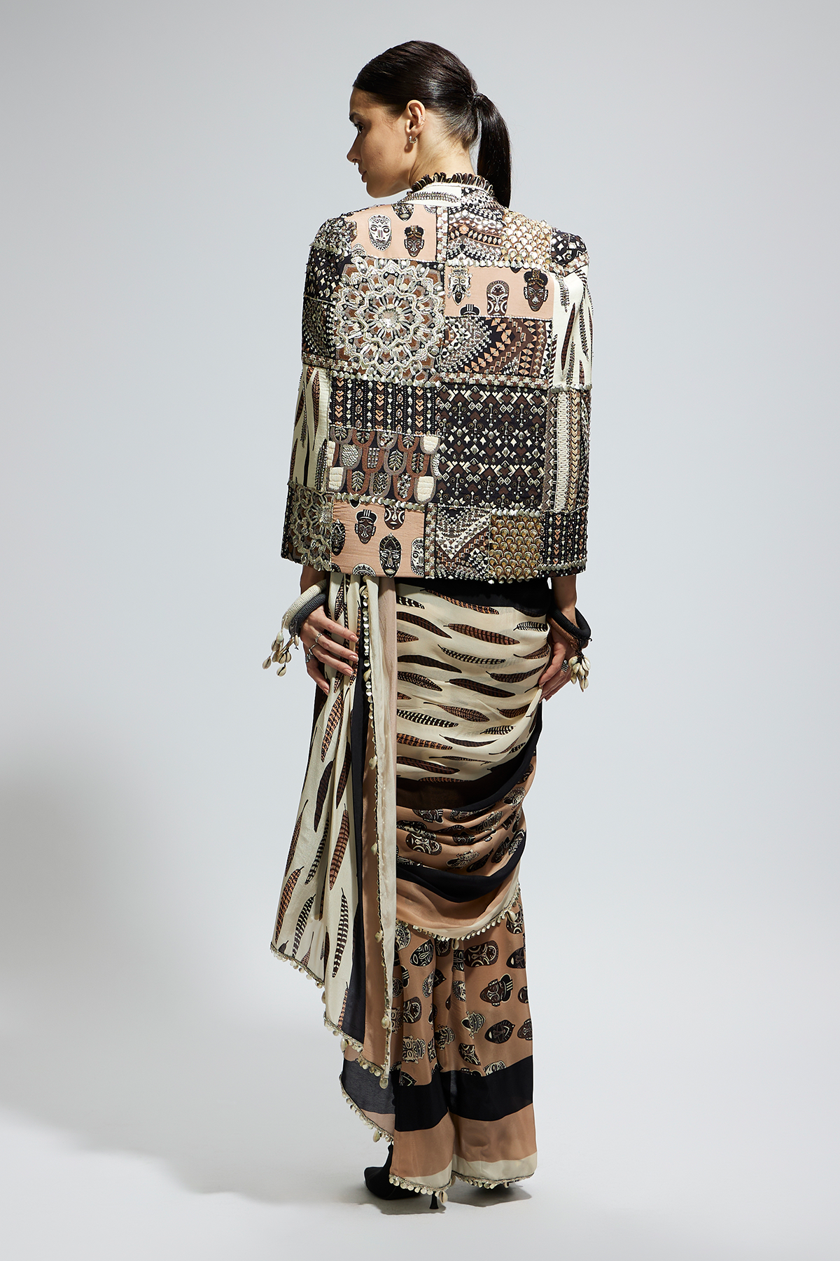 Mask and Feather Print Cascade Saree Paired with Metallic Scallop Bustier with Patchwork Cape Jacket